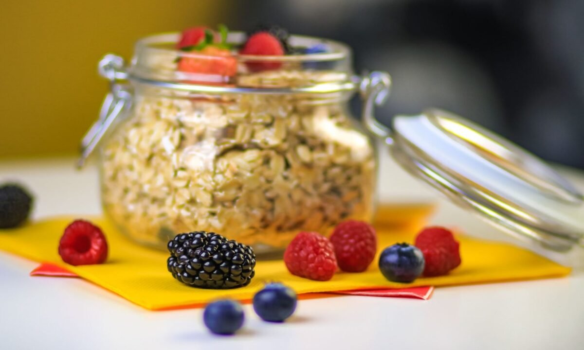 High protein overnight oats in a glass jar topped with fresh berries