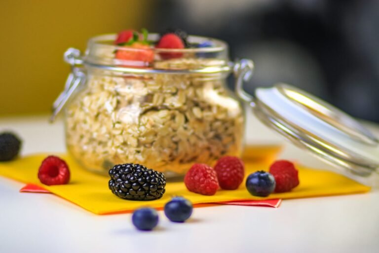 High protein overnight oats in a glass jar topped with fresh berries