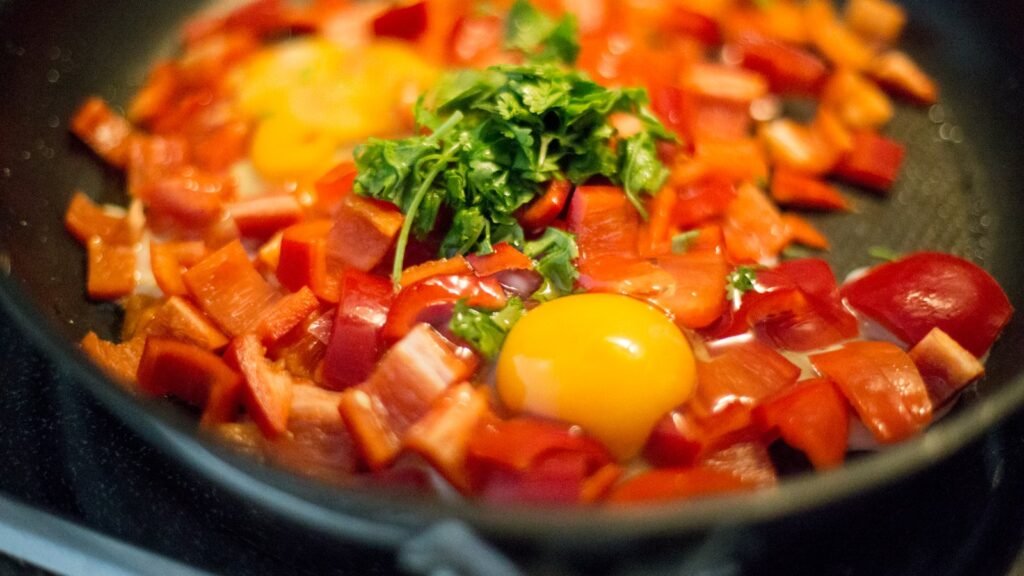 Eggs cooked on top of sweet potato hash in a pan
